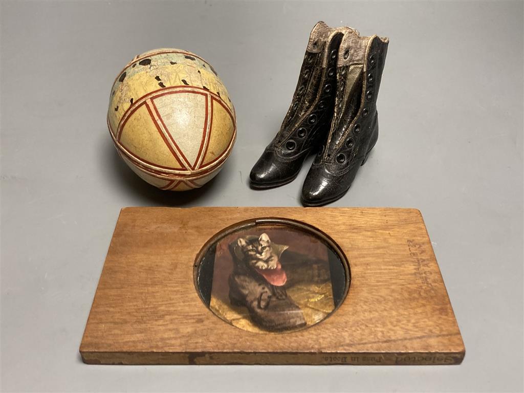 An early 20th century leather decorated easter egg, a pair of 19th century miniature ladies boots and a magic lantern Puss in Boots